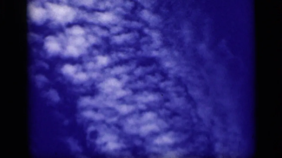 The final 1946 8mm frame shows clustered pale clouds against deep blue, with grain and dark borders.