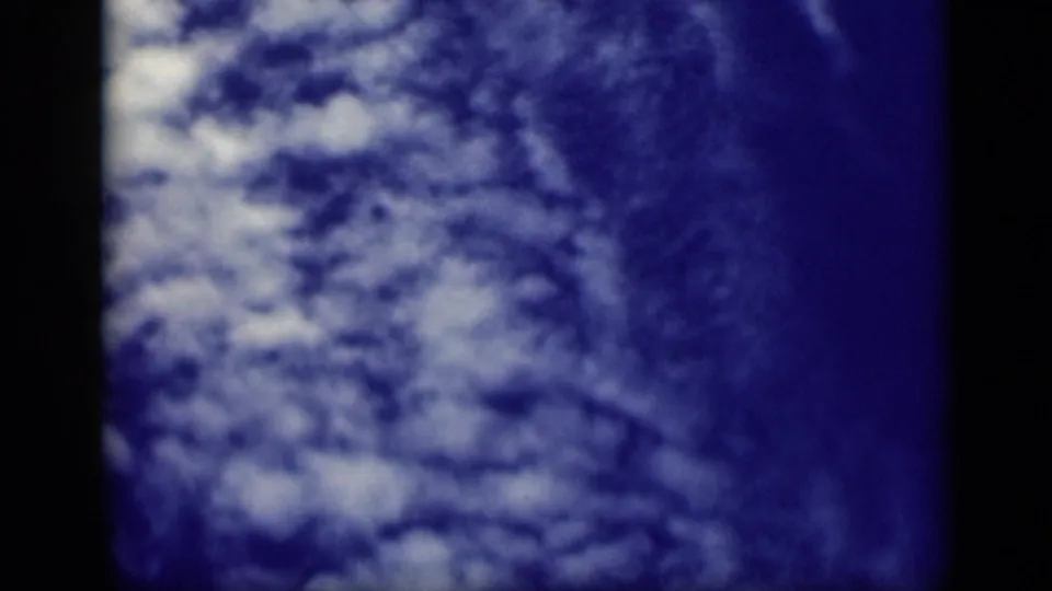 1946 Cairo 8mm frame showing broken white clouds over blue sky, with pronounced grain and dark film borders.