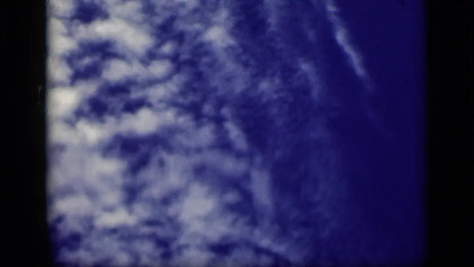 1946 Cairo 8mm frame of textured white cloud formations against blue sky, bordered by dark film edges.