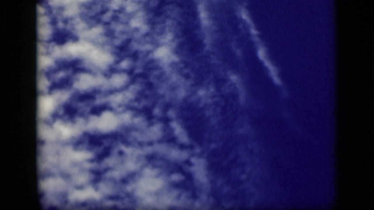 1940s 8mm frame showing blue sky and cloud texture before the deck navigation view appears.