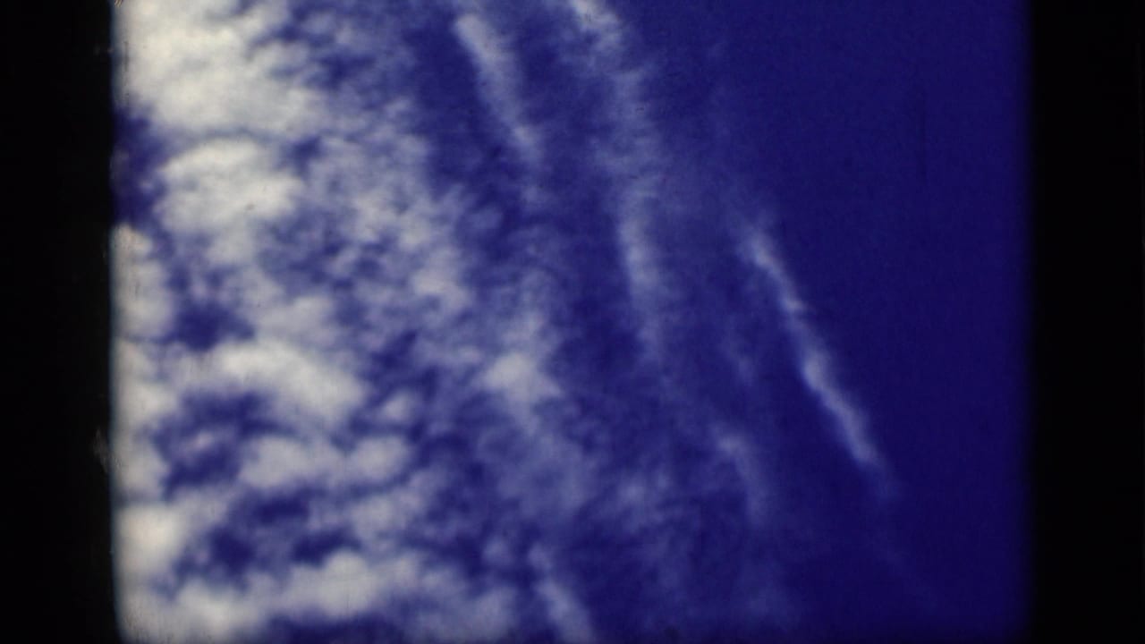 Blue sky and clouds with dark vertical film borders at the sides.