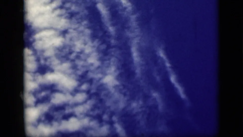 Blue-tinted 8mm sky frame with cloud texture, likely part of the Cairo travel reel metadata.