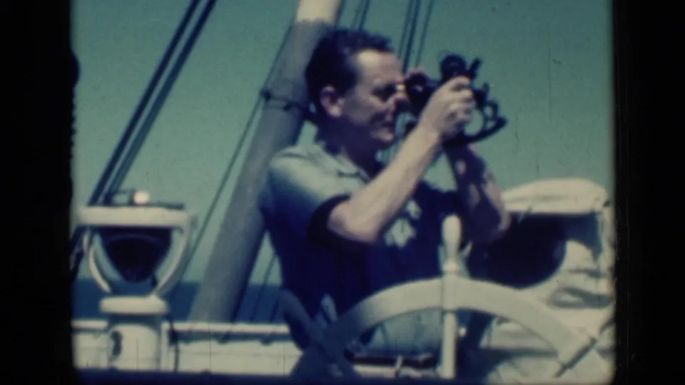 In the Cairo 1946 home-movie metadata, an adult man on deck uses a sextant beside a ship wheel and rigging.