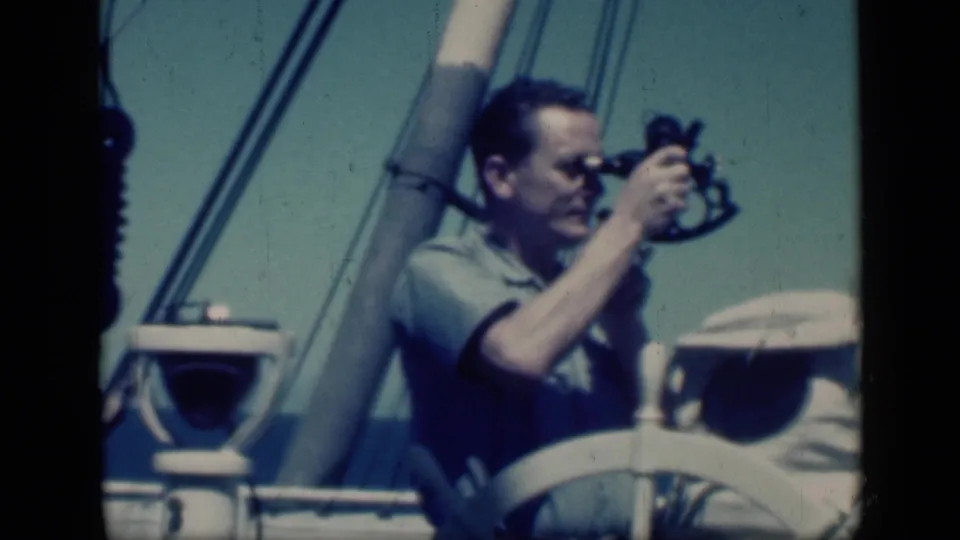 A mid-century travel frame shows the man using the sextant with the mast, rigging lines, and white boat rail visible around him.