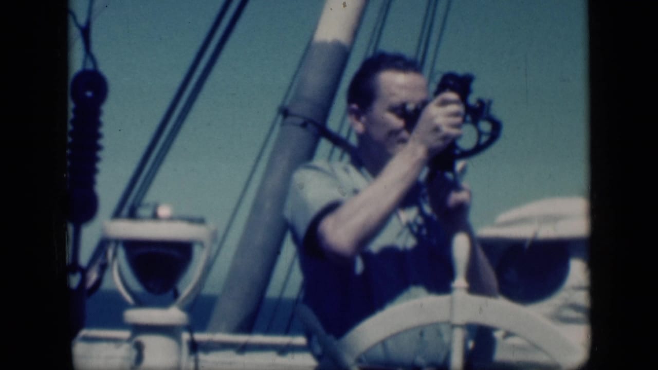 In Cairo, Egypt in 1946, a man aboard a sailboat raises a small cine camera near a white wheel, mast, and rigging.