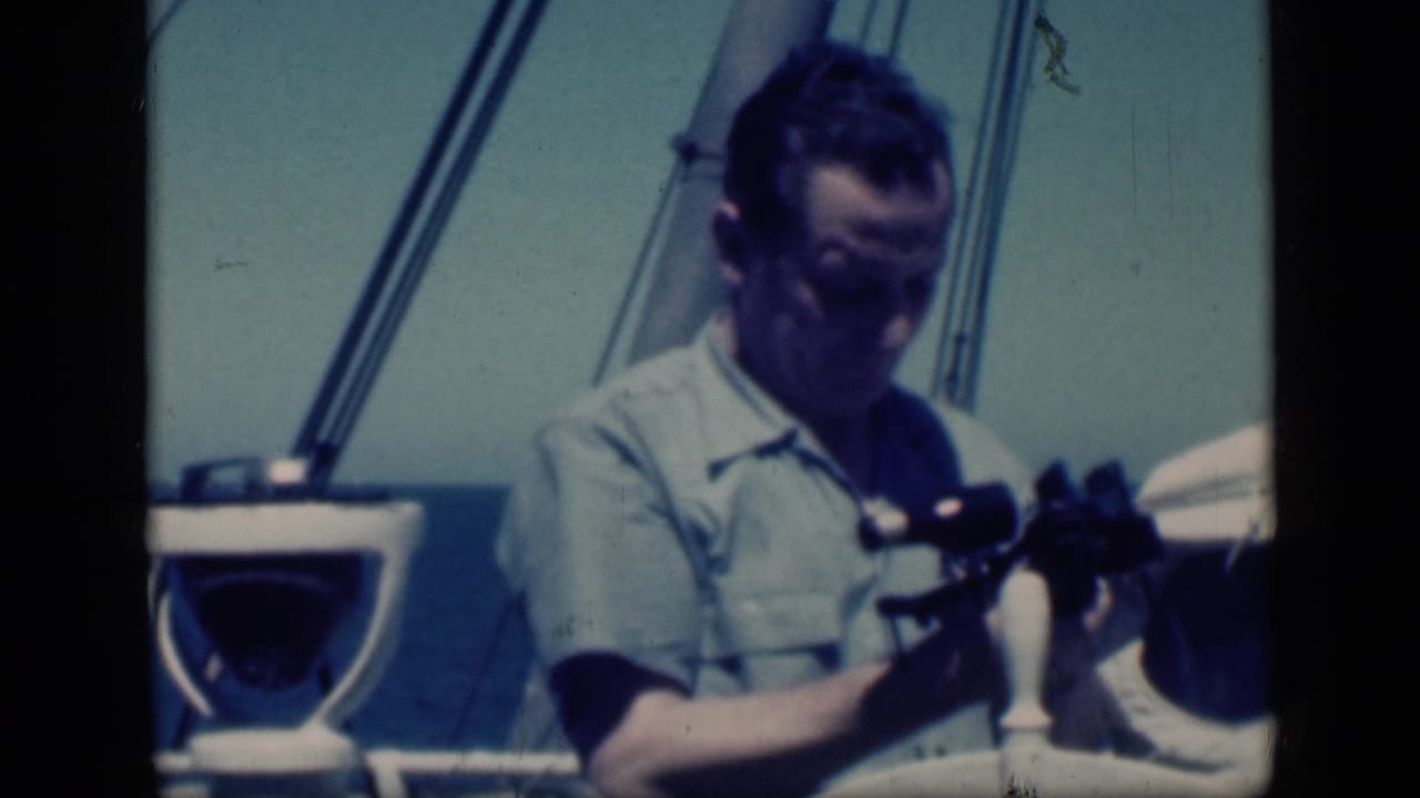 In 1946 Egypt travel footage, an adult man on a boat looks down while holding binoculars near rigging and sea.