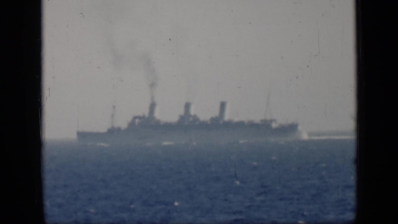 Distant three-funnel ocean liner at sea in 1946 Egypt-cataloged 8mm footage, with smoke rising above the vessel.