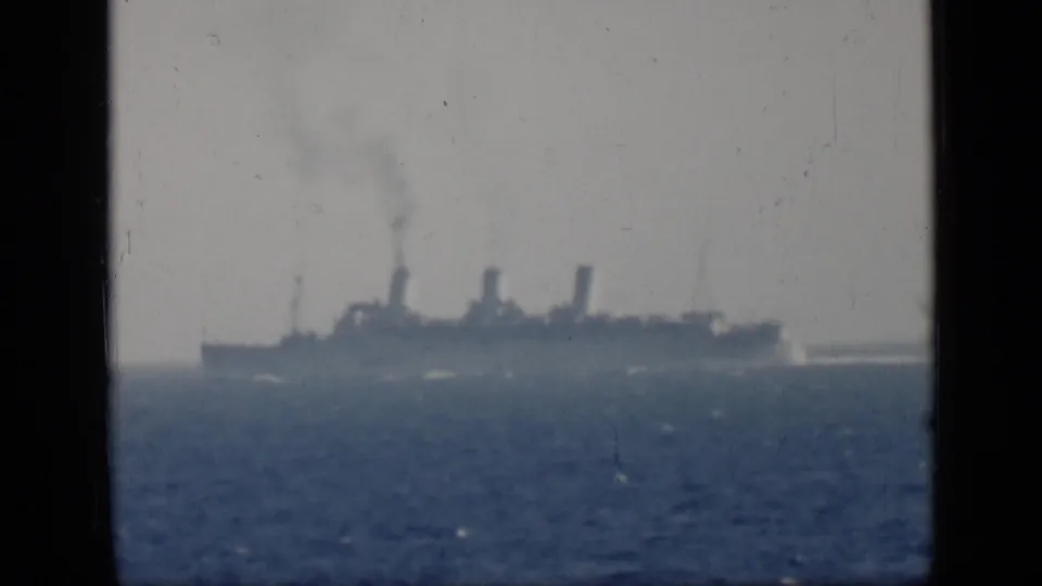 Distant three-funnel ocean liner at sea in 1946 Egypt-cataloged 8mm footage, with smoke rising above the vessel.