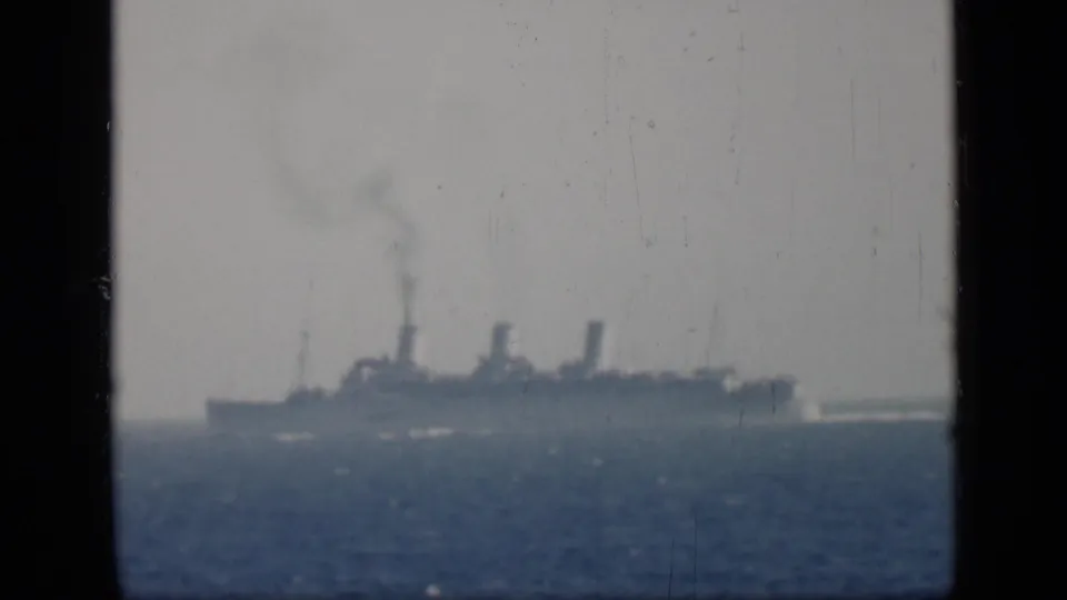 A distant passenger ship with three funnels travels along the horizon in grainy 8mm home-movie footage cataloged to 1946 Egypt.
