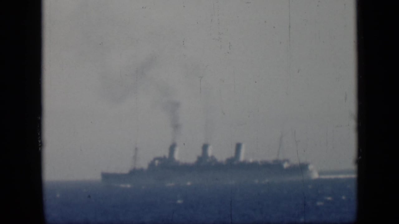 1946 Egypt-associated 8mm frame showing a distant multi-funnel steamship on calm seas with smoke rising.