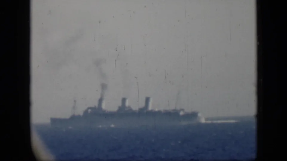 1946 Egypt-associated home-movie frame showing a distant steamship on the water, with haze, scratches, and dark frame edges.