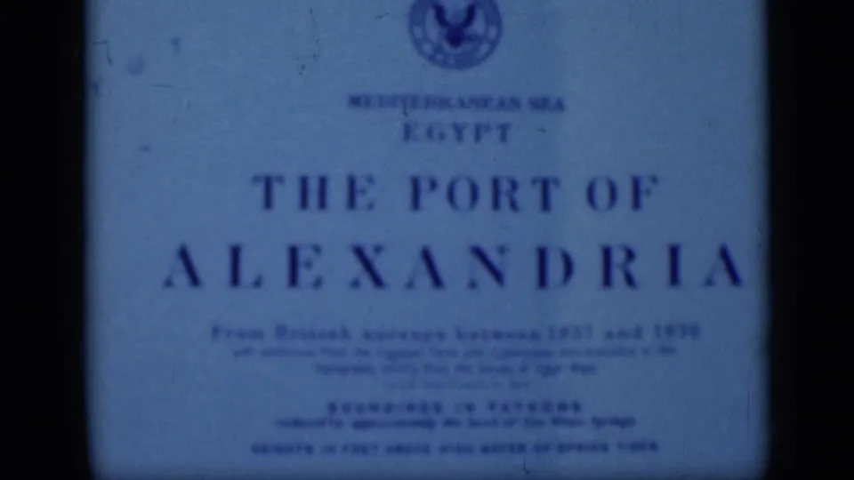 Blue-tinted 1946 Egypt home-movie frame of an English Alexandria port title card, seen through soft film focus.