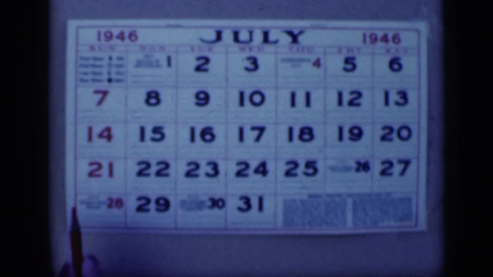 Cairo, Egypt 1946 home-movie frame showing a July 1946 wall calendar in close-up, with the date grid filling the frame.