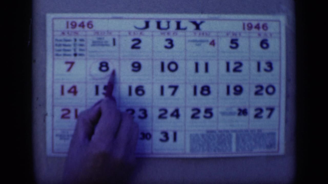 Close view from Cairo 1946 home-movie footage showing a hand and pen marking a July 1946 calendar.