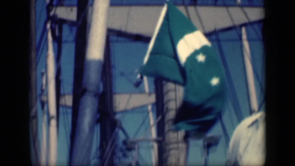 Outdoor home-movie frame from the Cairo 1946 clip showing a flag, poles, and rigging or ropes against the sky.