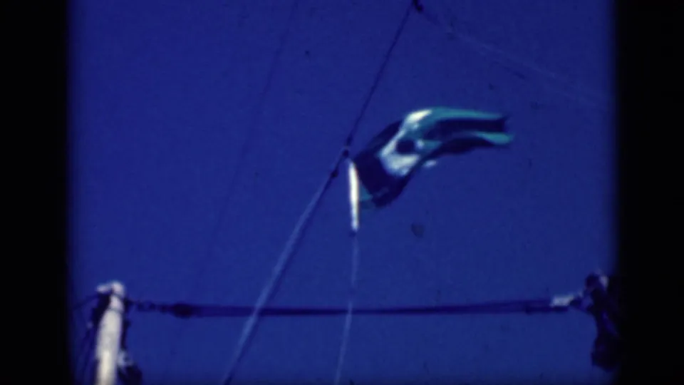 1946 Cairo frame showing the green crescent-and-star flag twisting above sailboat rigging, with mast top visible below.