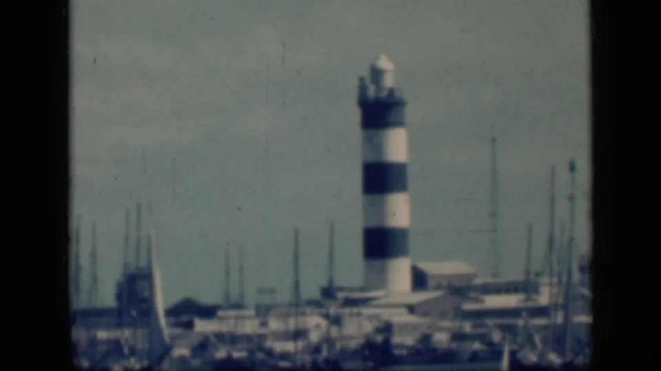 Soft 8mm frame of a striped harbor light and dockside masts, identified by supplied metadata as Cairo, Egypt, in 1946.