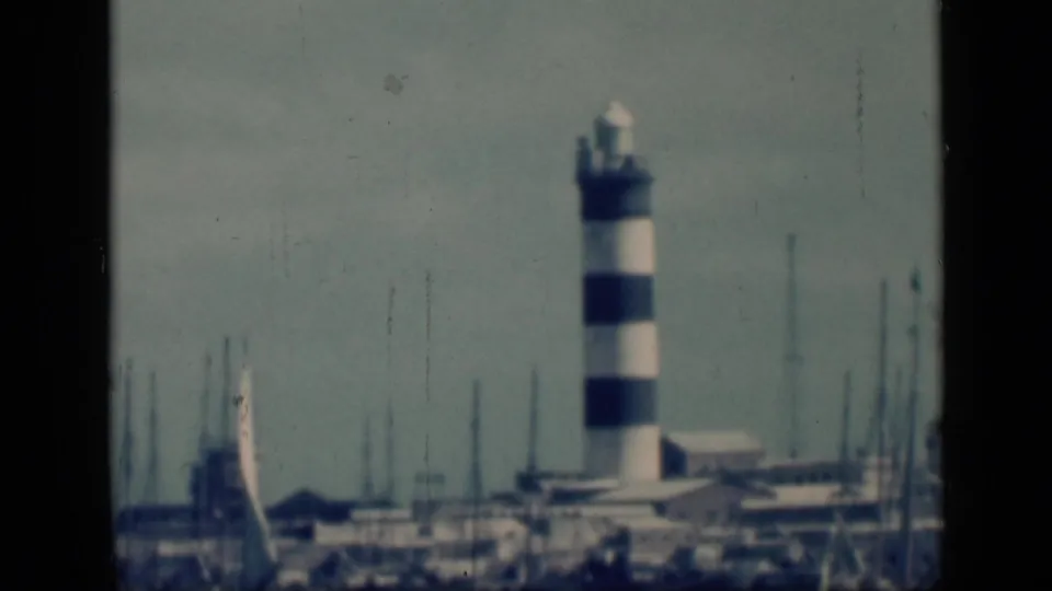 Final frame holds on the striped harbor light, marina masts, and low waterfront buildings in archival 1946 Cairo home-movie footage.