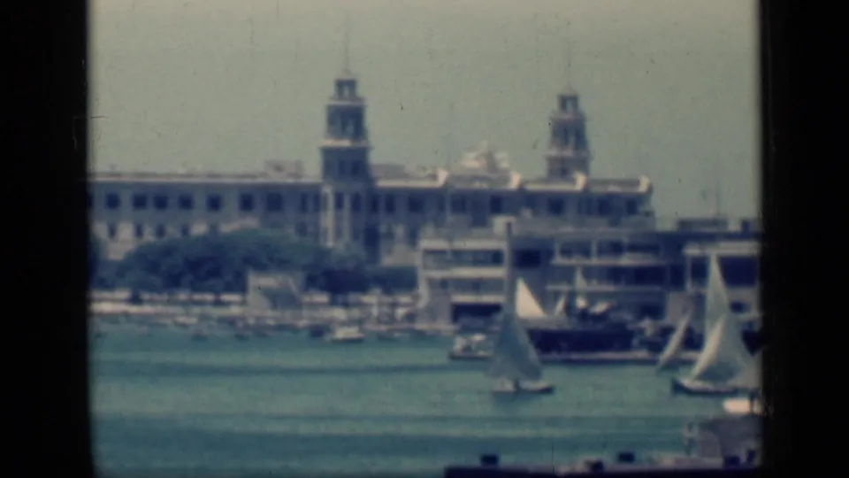 1946 Cairo waterfront view with multiple small sailboats, moored craft, and twin tower-like structures along the far shore.