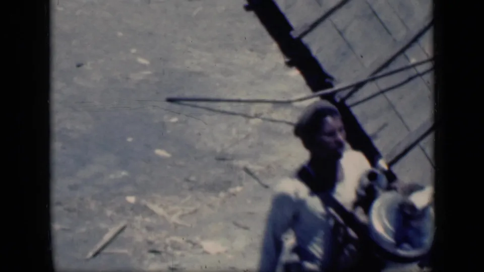 A softly focused 1946 Cairo frame shows the man near the right edge carrying a round object across bright ground.
