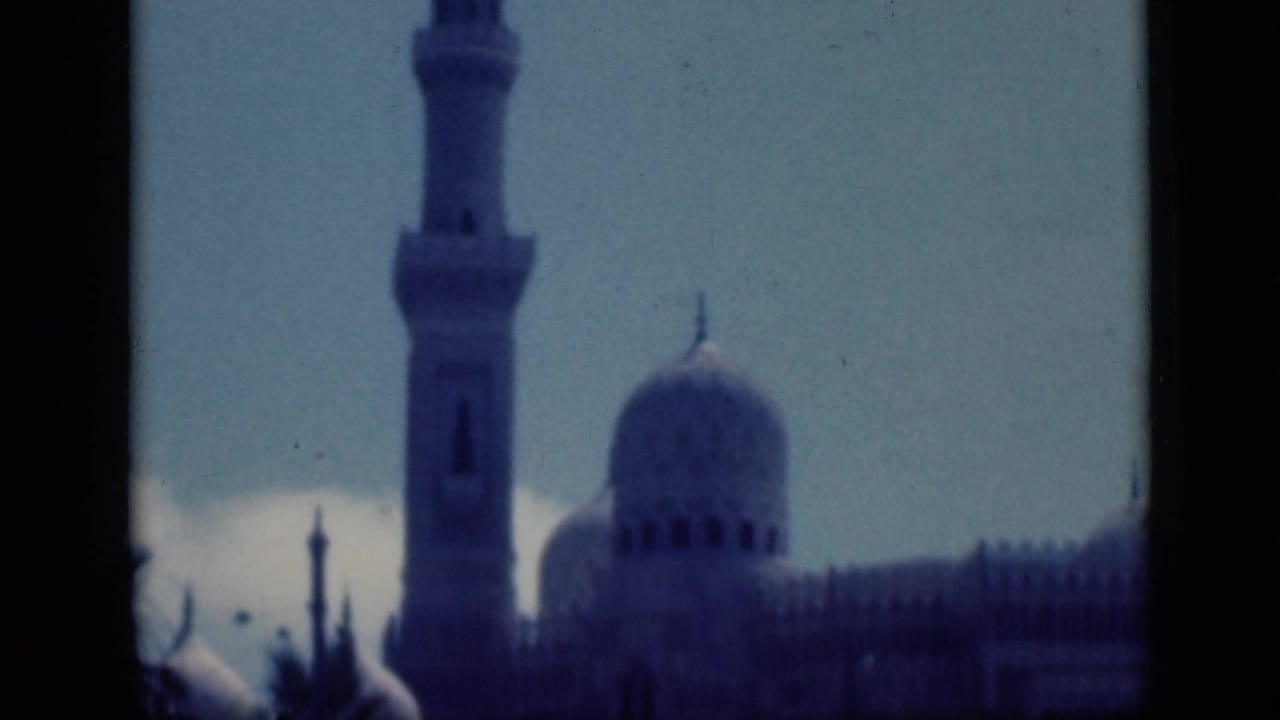 1946 Cairo 8mm frame showing a distant mosque minaret and dome with dark film or window borders.