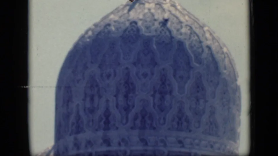 1946 Cairo 8mm frame showing close architectural detail on a mosque dome, with soft focus and blue-toned film texture.