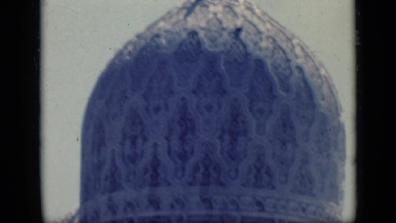 1946 Cairo 8mm frame showing a close blue-tinted patterned mosque dome against a pale sky.