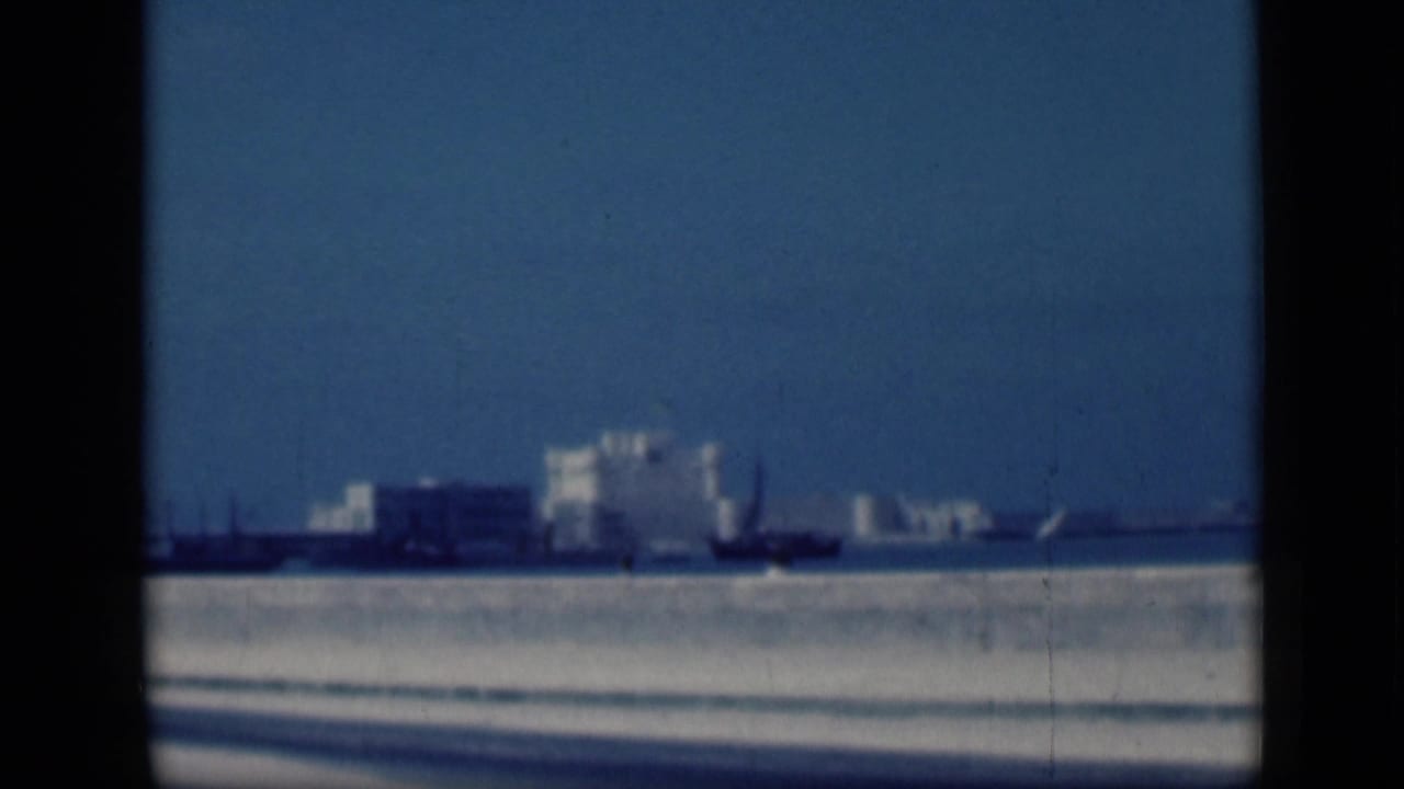 1946 Cairo 8mm view of a distant white castle-like landmark across water, seen softly through dark frame borders.