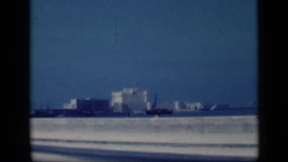 Soft 1946 Cairo home-movie frame showing the white landmark from across water with dark vertical borders in view.