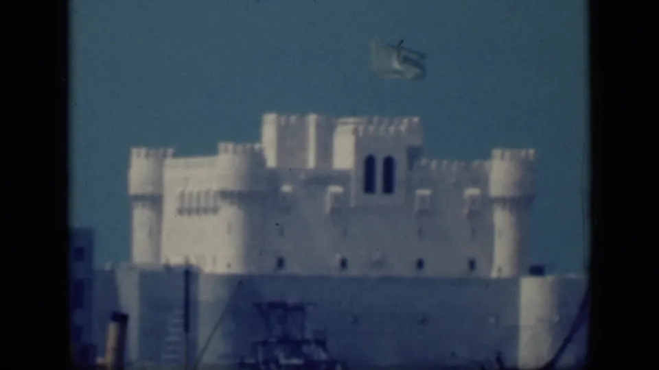 Closer 1946 Cairo view of a white crenellated landmark with towers and a flag flying above the roofline.
