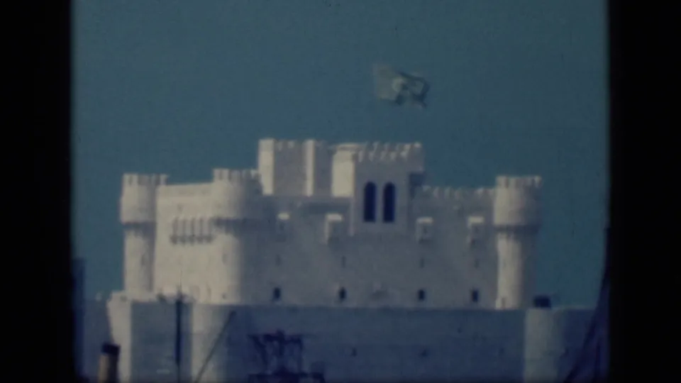 Final 1946 Cairo frame showing the same white towered structure with a faint waving blue flag above the roofline.