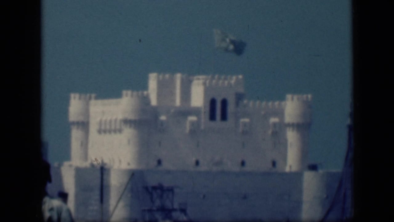 1946 Cairo home-movie frame showing a white castle-like building with corner towers and a small flag above the roofline.