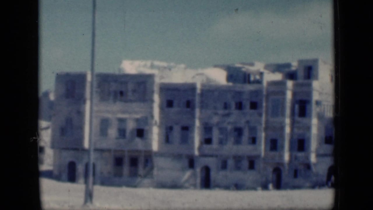 Weathered multi-story buildings with dark window openings and arched doorways.