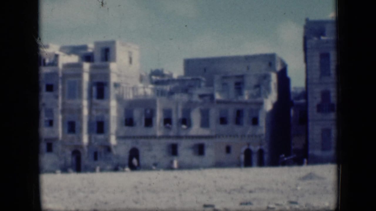 1946 Cairo street view showing pale European-style buildings with arched entrances and shuttered windows in soft 8mm color.