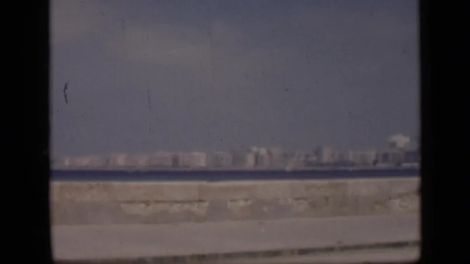 The 1946 Egypt waterfront view continues without people in frame, showing the seawall, water, and distant skyline.