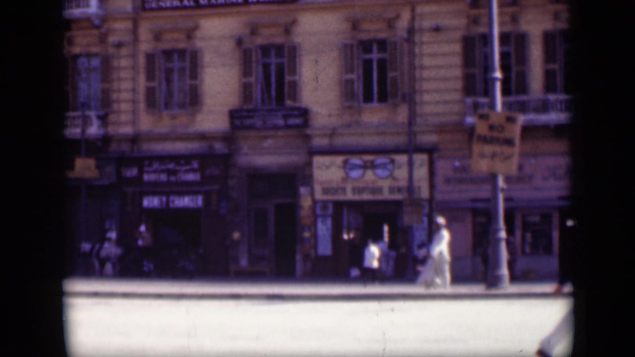Pedestrians pass shops with visible money changer and marine works signs.