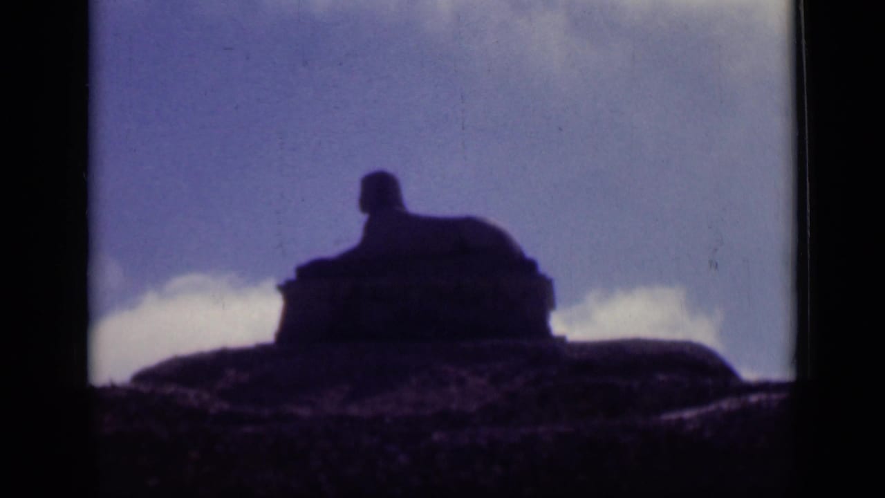Final 1946 Cairo frame showing the sphinx-like monument held in silhouette, with a bright cloud line behind the rocky base.