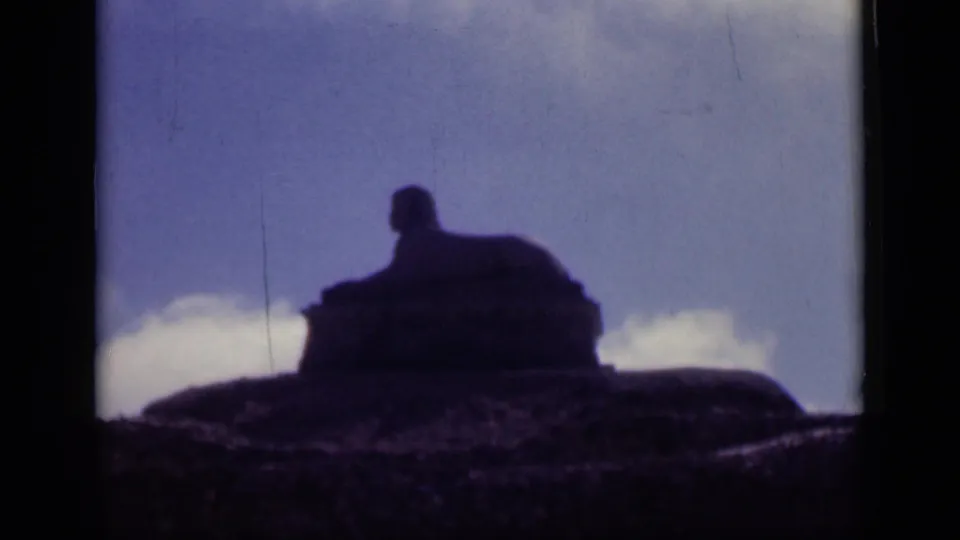 1946 Cairo home-movie frame showing the Sphinx in dark silhouette against sky, with visible 8mm frame edges.