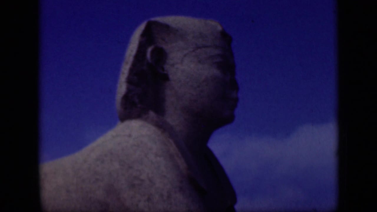 1946 Cairo/Giza home-movie frame showing the Great Sphinx head and shoulder in side profile under a vivid blue sky.