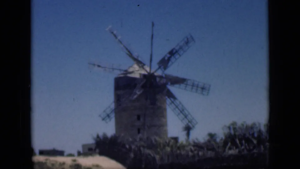 1946 Cairo home-movie frame showing a weathered windmill tower in an arid setting under a clear blue sky.
