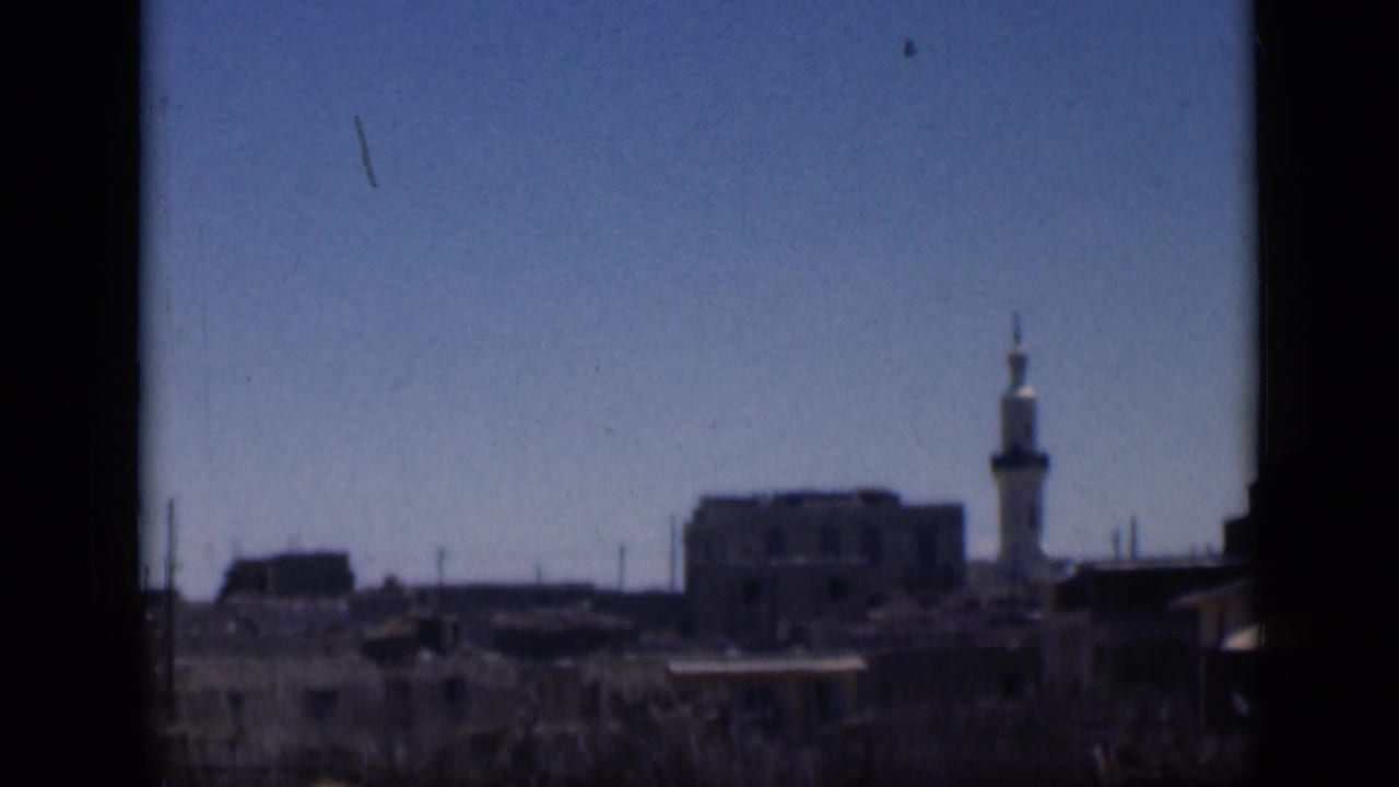 1946 Cairo 8mm frame showing a distant minaret, low urban buildings, open sky, and visible film wear.