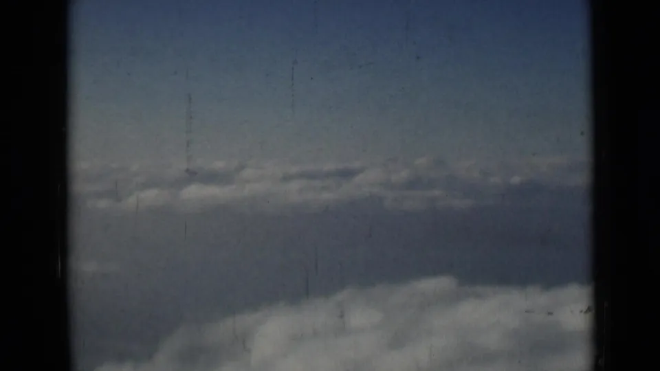 1946 8mm home-movie frame attributed to London, showing blue sky and layered clouds with visible film gate edges.