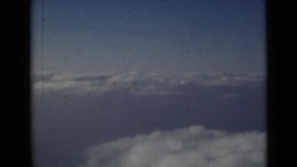 Final 8mm still from the London-attributed 1946 cloud clip, showing blue sky, soft clouds, and visible scan borders.