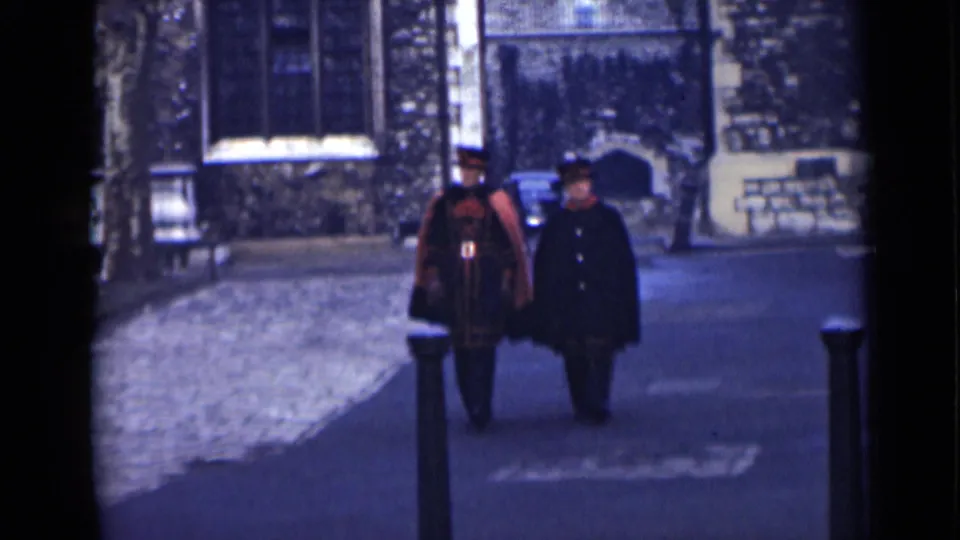 At the end of the 1946 London shot, the men are nearest the camera, with ceremonial dress, dark overcoat, bollards, and stone architecture visible.