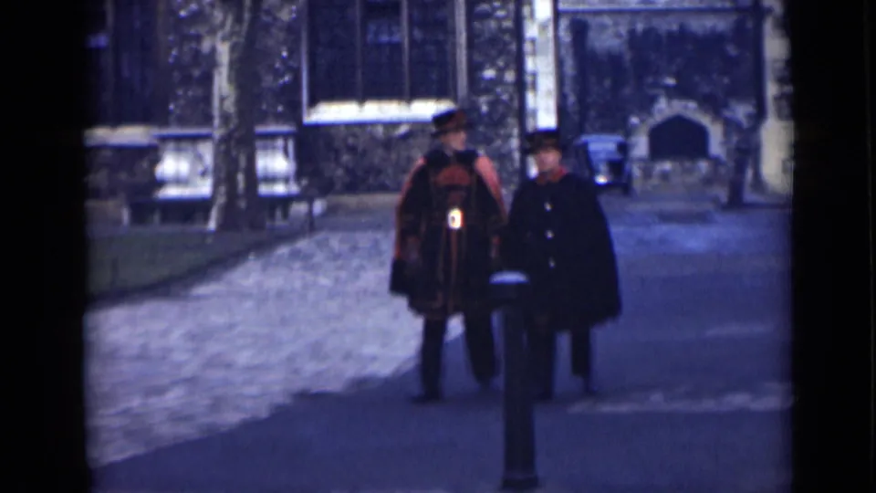 The London street scene shows the uniformed man and a second man in a dark coat moving closer, with stone walls and windows behind them.