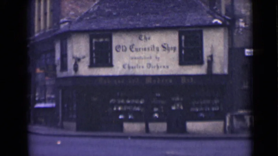Soft 8mm color view of The Old Curiosity Shop exterior on a quiet London street in 1946.