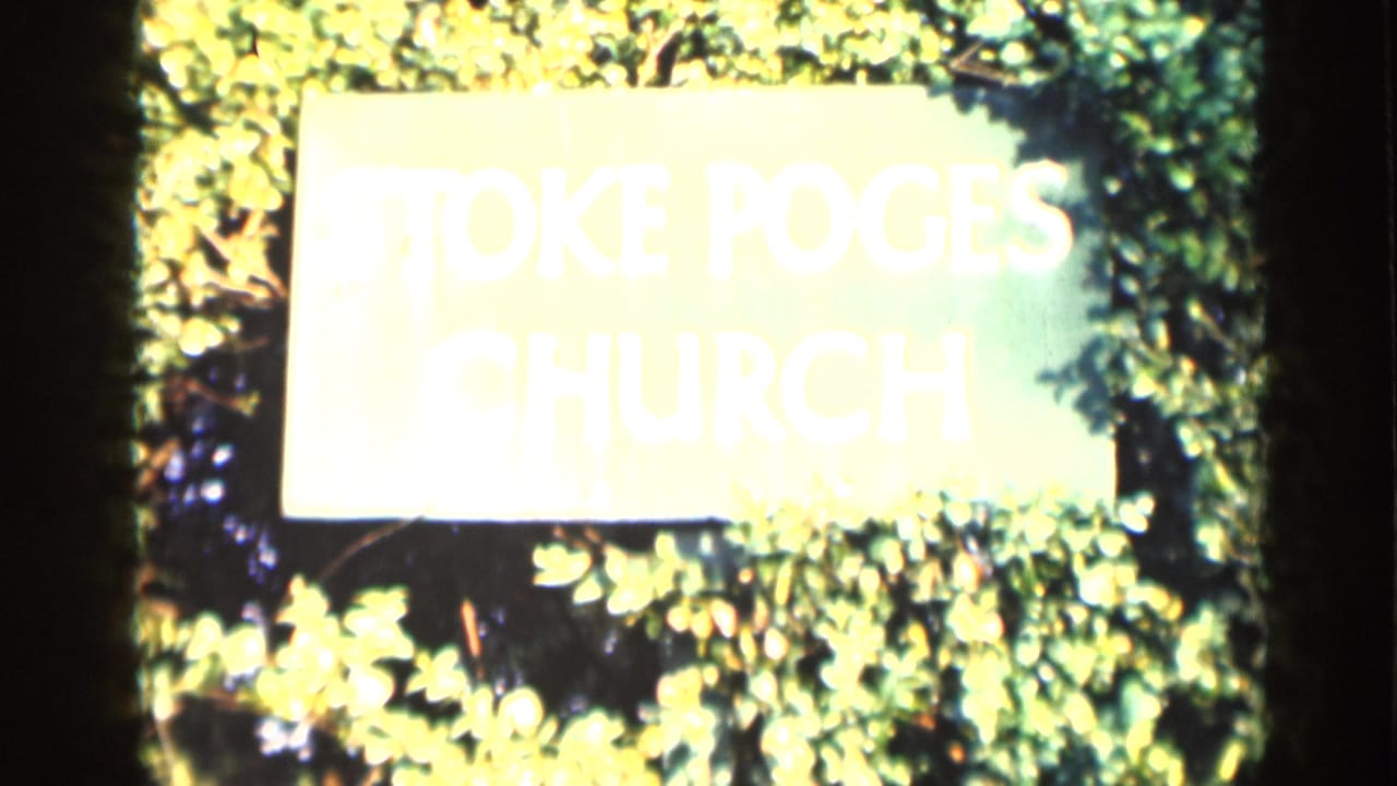 Bright Stoke Poges Church sign partly washed out among leafy foliage.