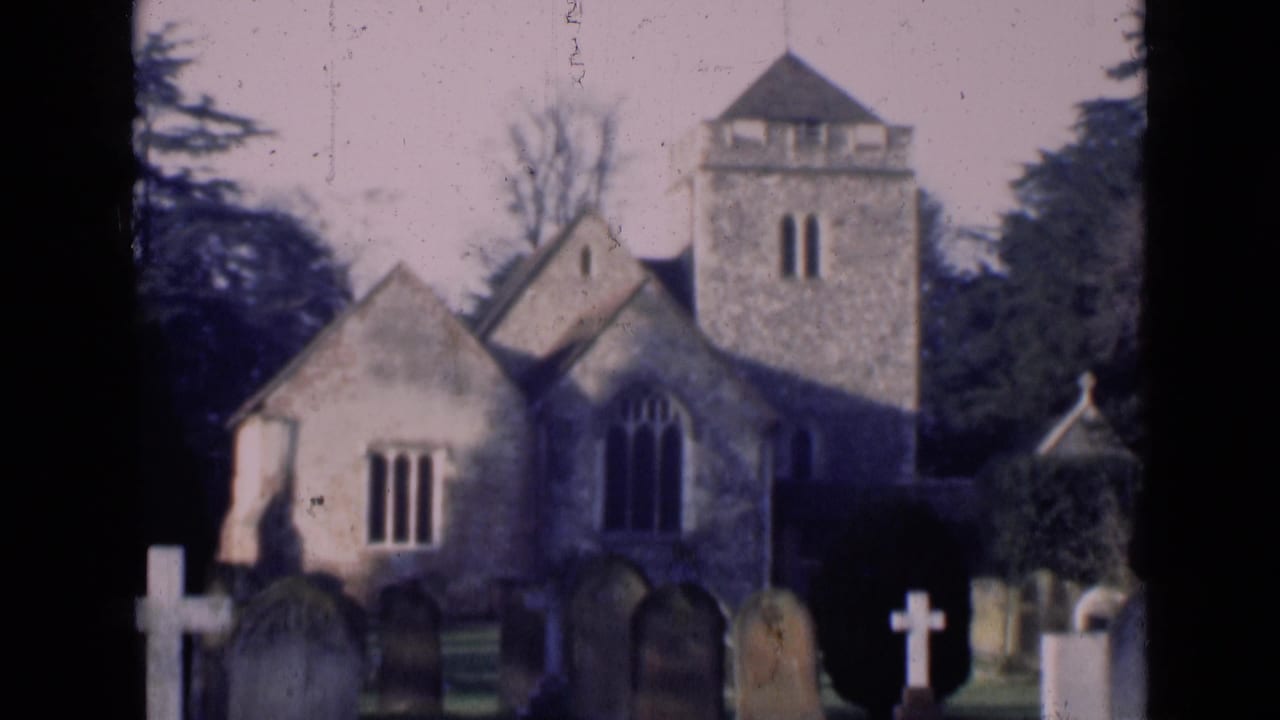 Churchyard view with stone tower, arched windows, and tombstones.