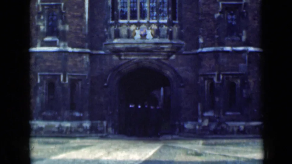 1946 London 8mm frame showing a dark masonry facade with a large arched entrance, window, and courtyard foreground.