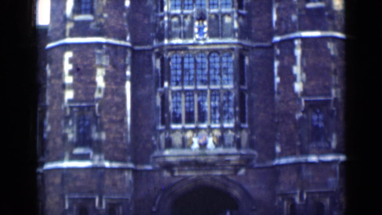 Historic brick facade with large leaded windows, balcony stonework, and film gate edge.